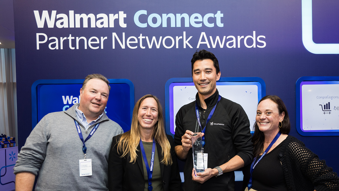 Two men and two women holding an award